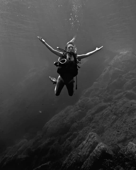 Foto Diving Chia: Braccia spalancate sopra una scogliera. Si chiama gratitudine in assetto neutro.